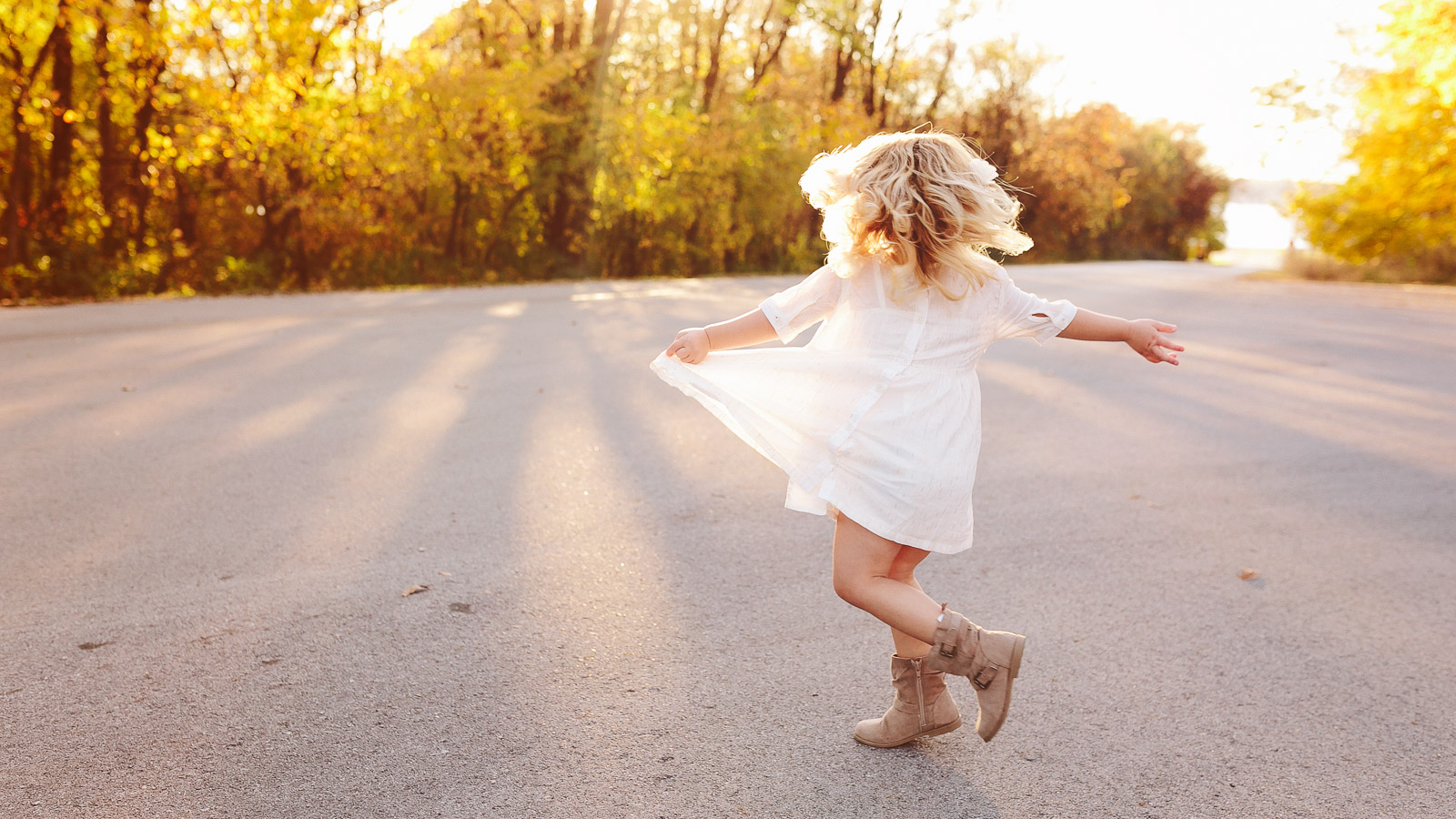 photograph of a young girl twirling in a white dress at saylorville lake in iowa.