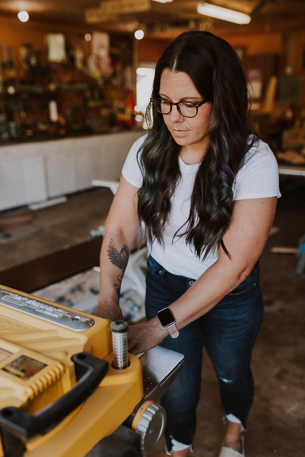 environmental headshot of a woodworker as she creates a new piece of furniture in her woodshop in johnston iowa